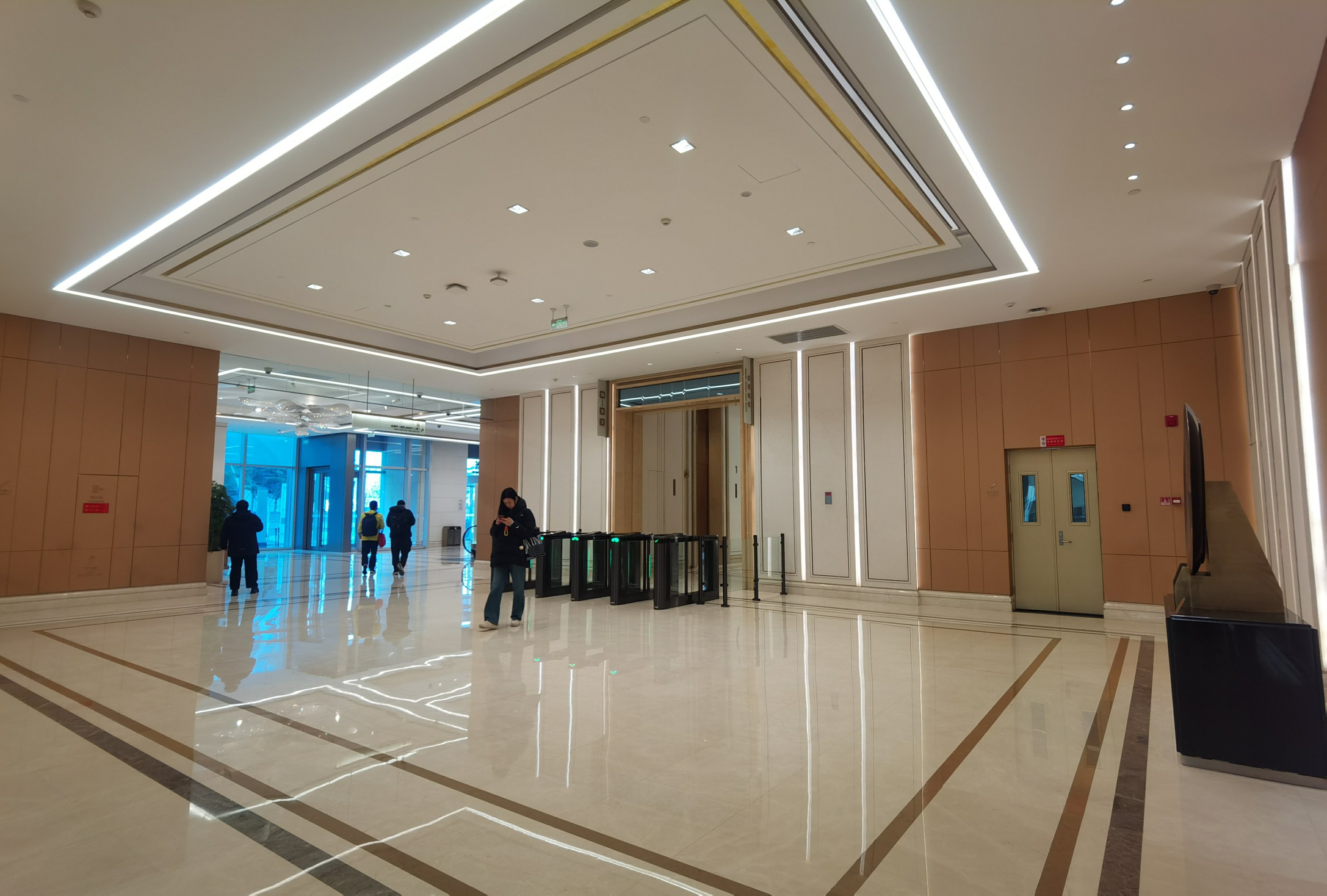 正大中心大堂电梯厅实景，闸机与大理石地面